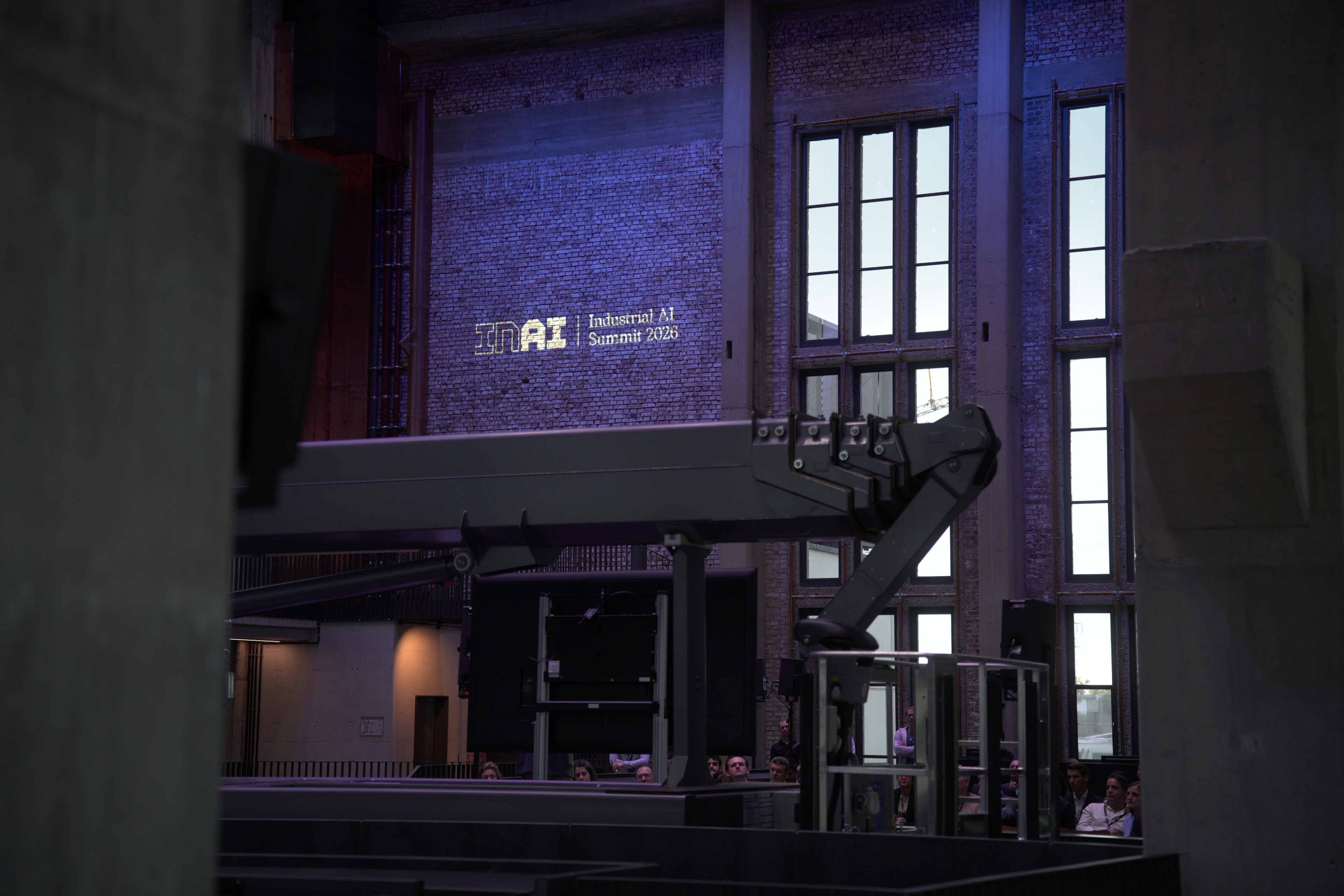 Industrial AI Summit 2026 identity projected onto the brick wall at Bergson